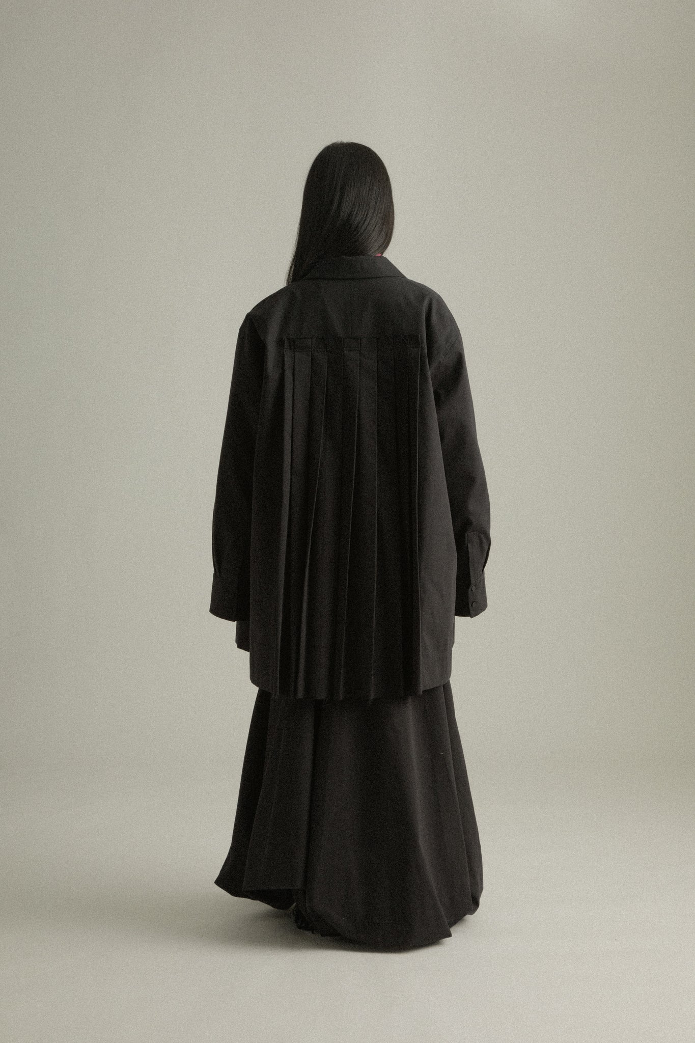 Back view of Assia Jacket, featuring signature pleats for added movement.