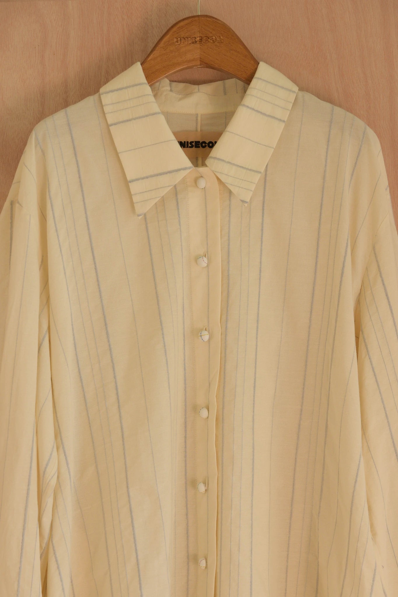 Detail of fabric with visible blue threads pressed by hand, and fabric-covered button