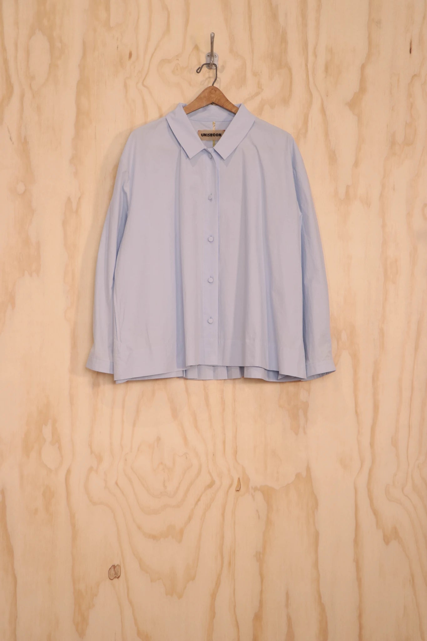 Bea Top in light blue organic cotton, front view on hanger.