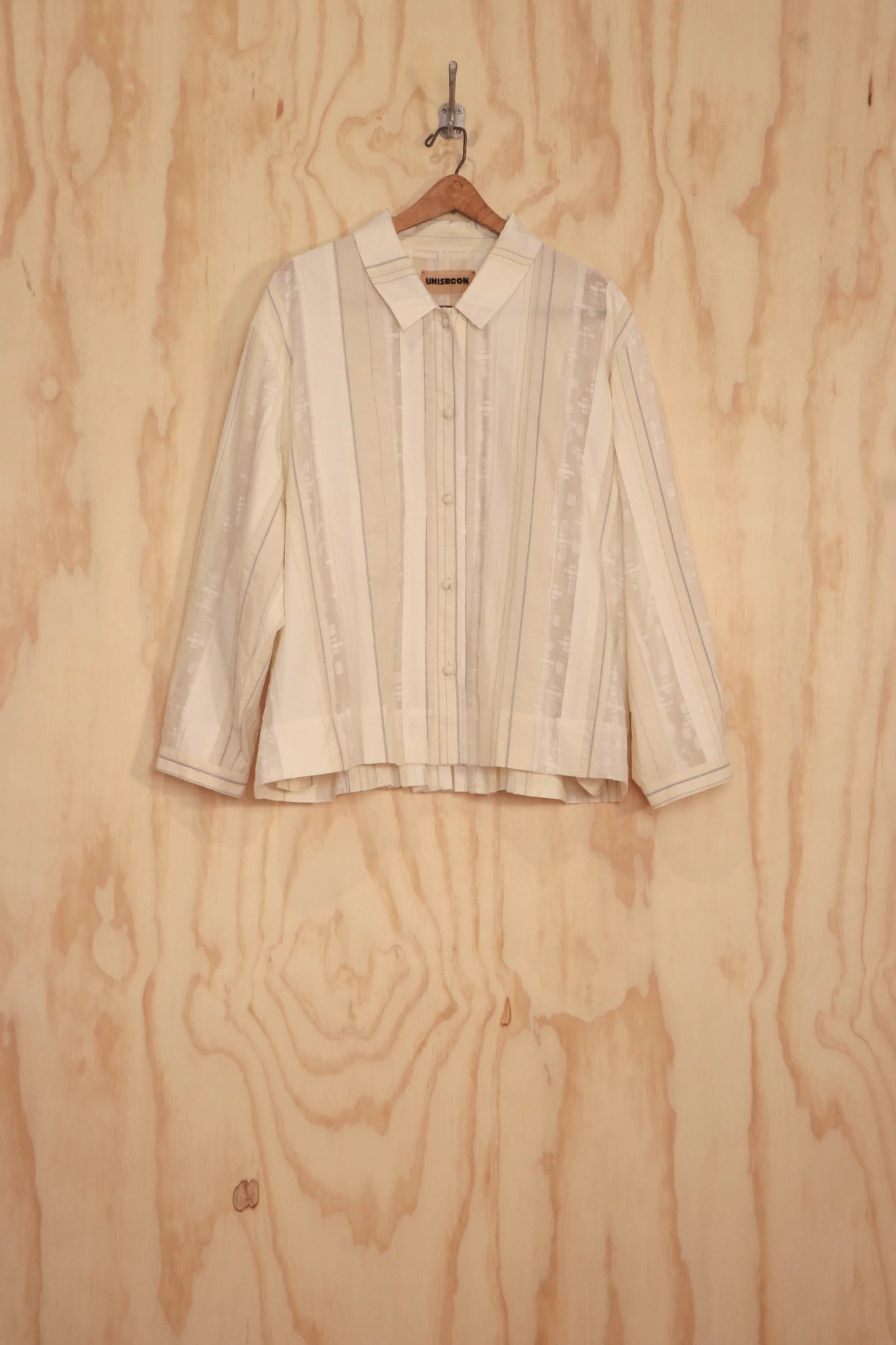 Bea Top in ivory organic cotton with mixed-texture panel, front view on hanger.