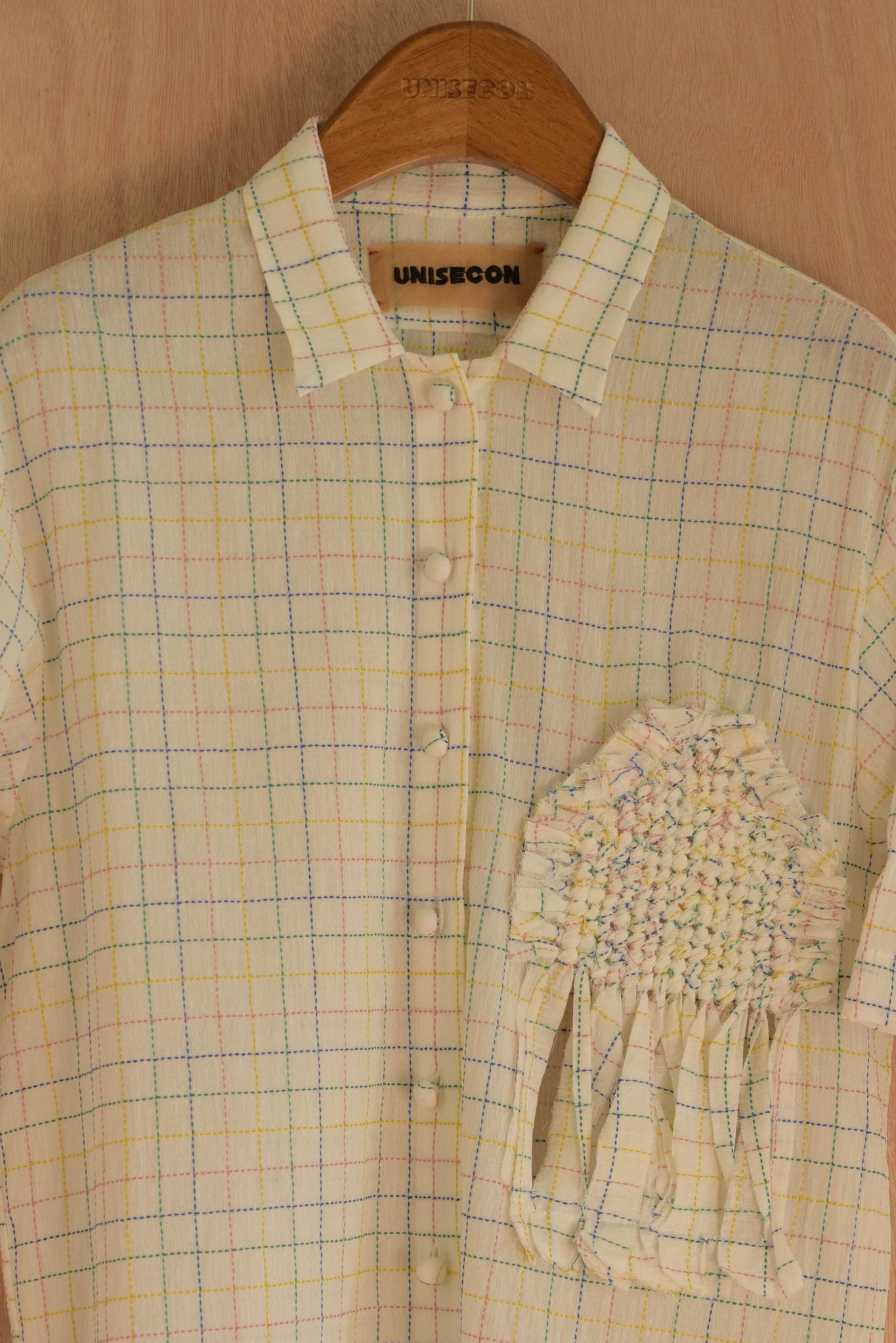 Close-up of front hand-woven decorative patch on June Top