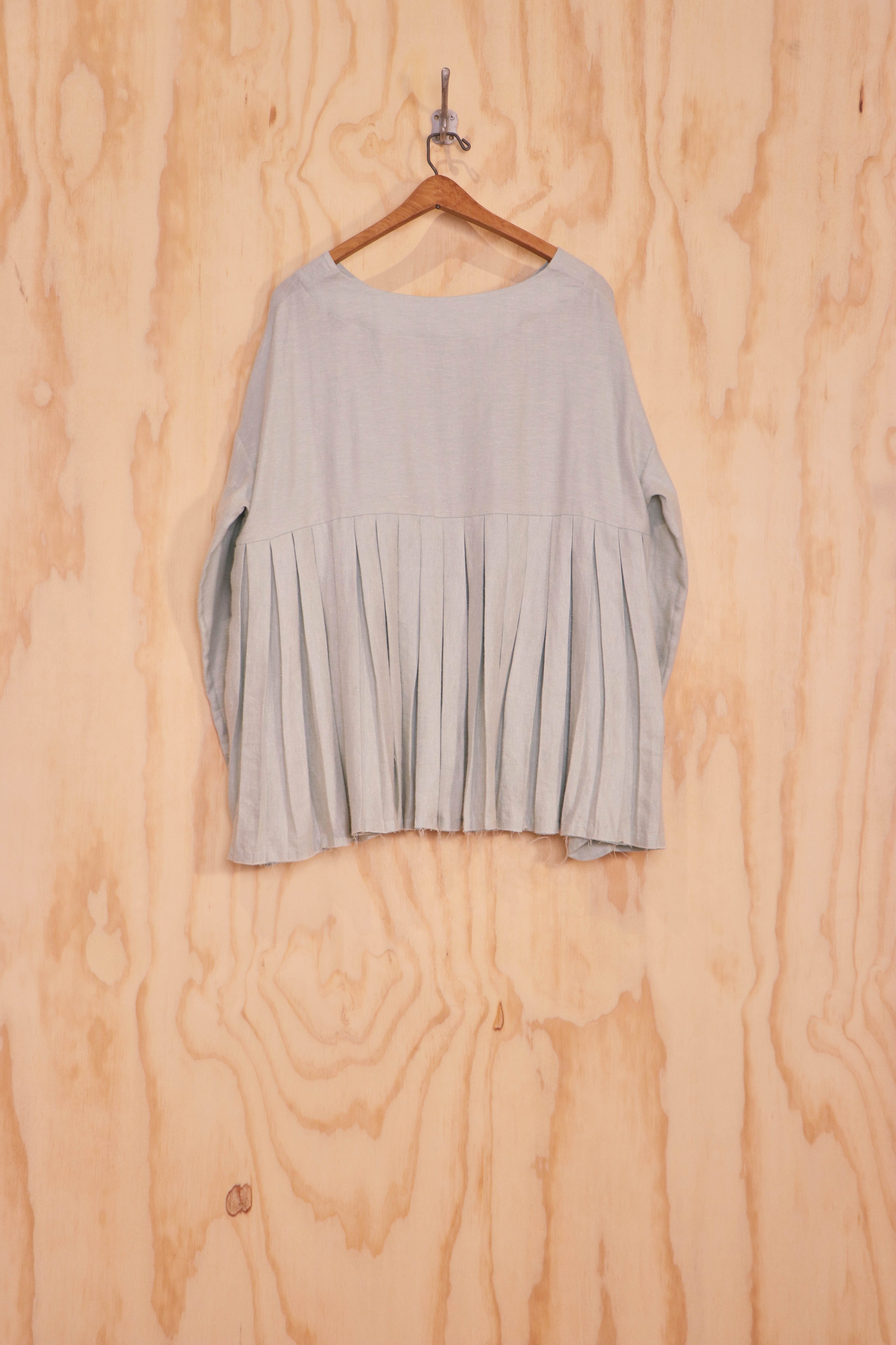 Back view showing fuller pleats and lower scoop neckline