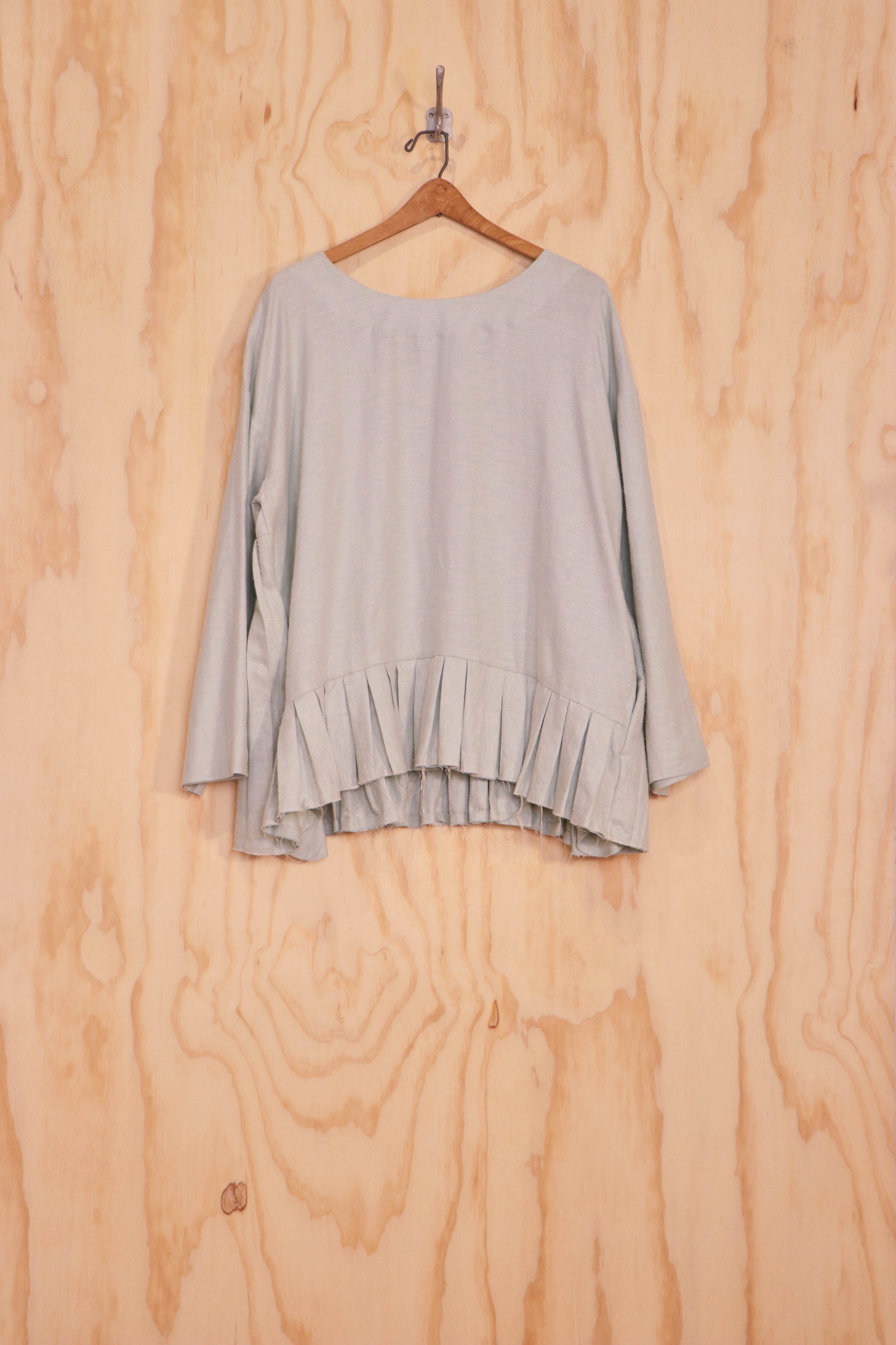 Front view of Lucie Top in ivory linen–cotton with asymmetric pleated hem