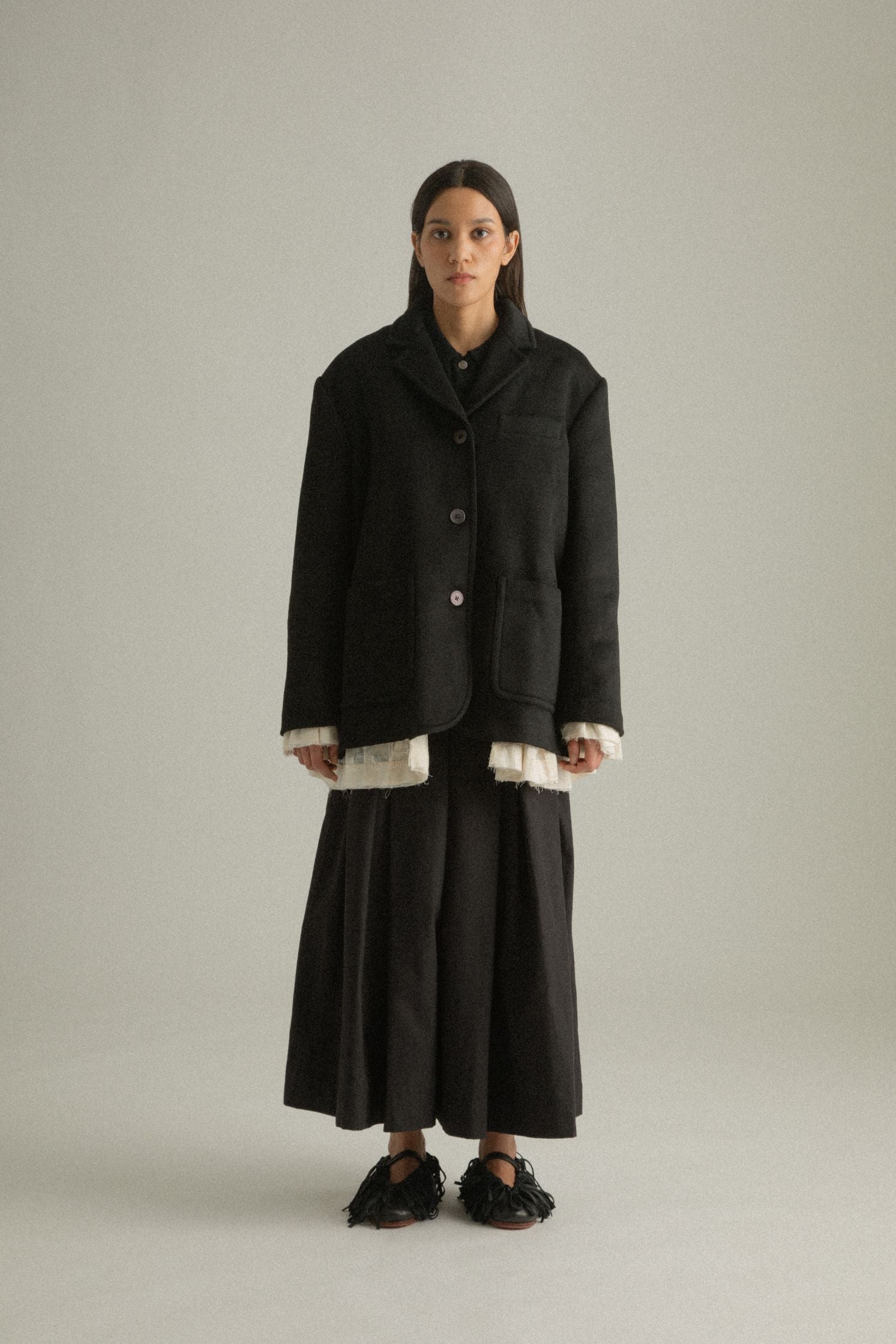 Full front view of the Martha Coat showcasing the structured black wool side with clean lapels and button closure.