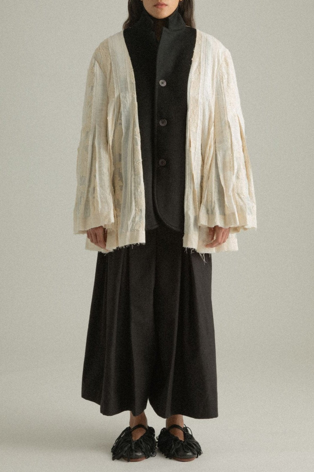 Cropped front view of the Martha Coat’s cream patchwork side, showcasing intricate fabric details.