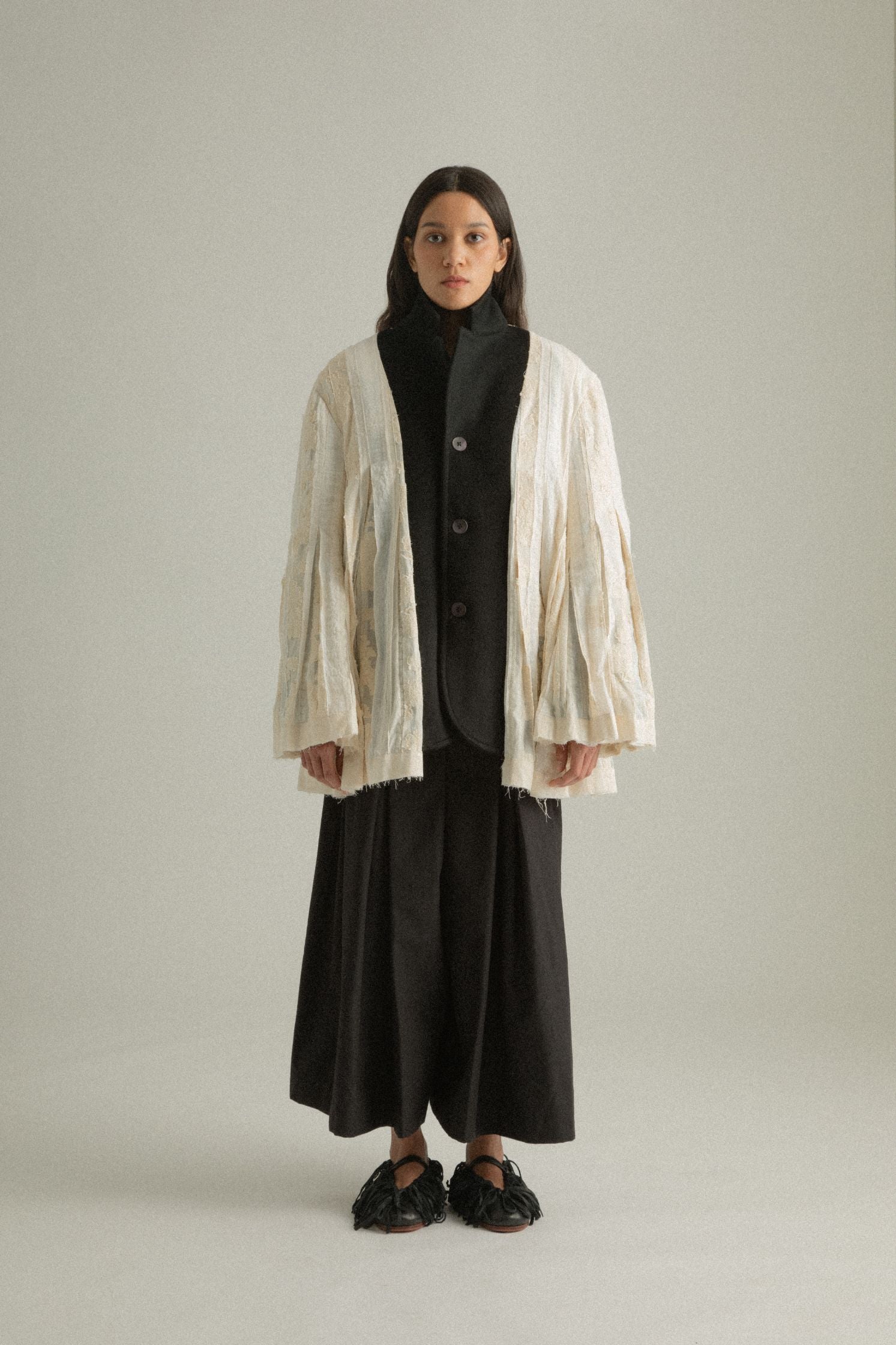 Full front view of the Martha Coat showcasing the textured cream patchwork side with pleated details.