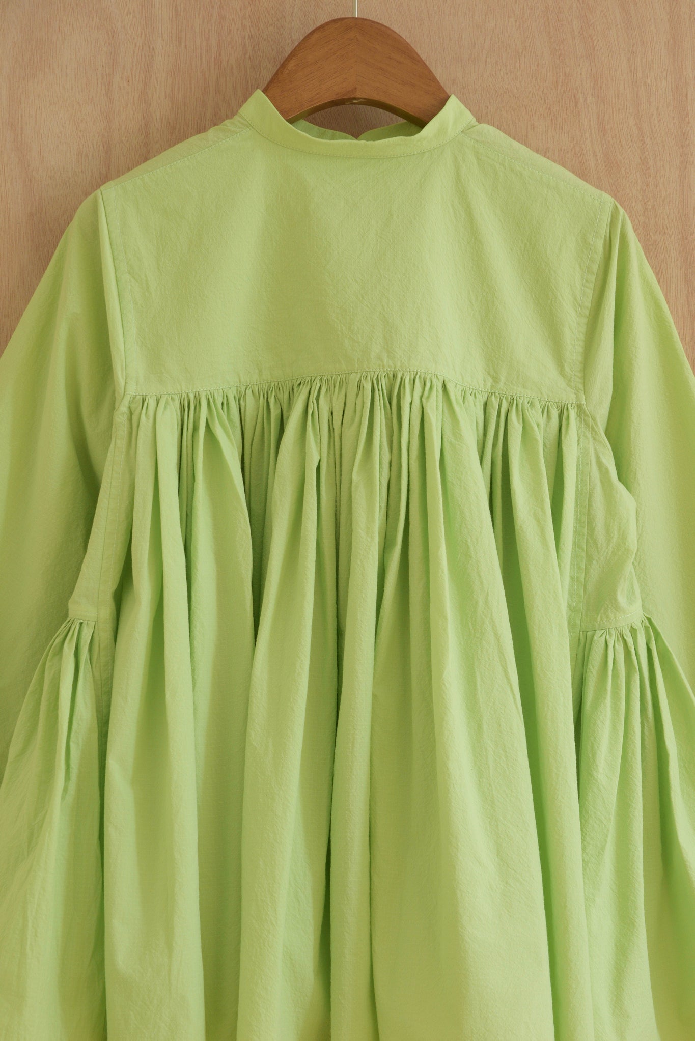 Textured organic cotton fabric in light green with subtle crinkle finish