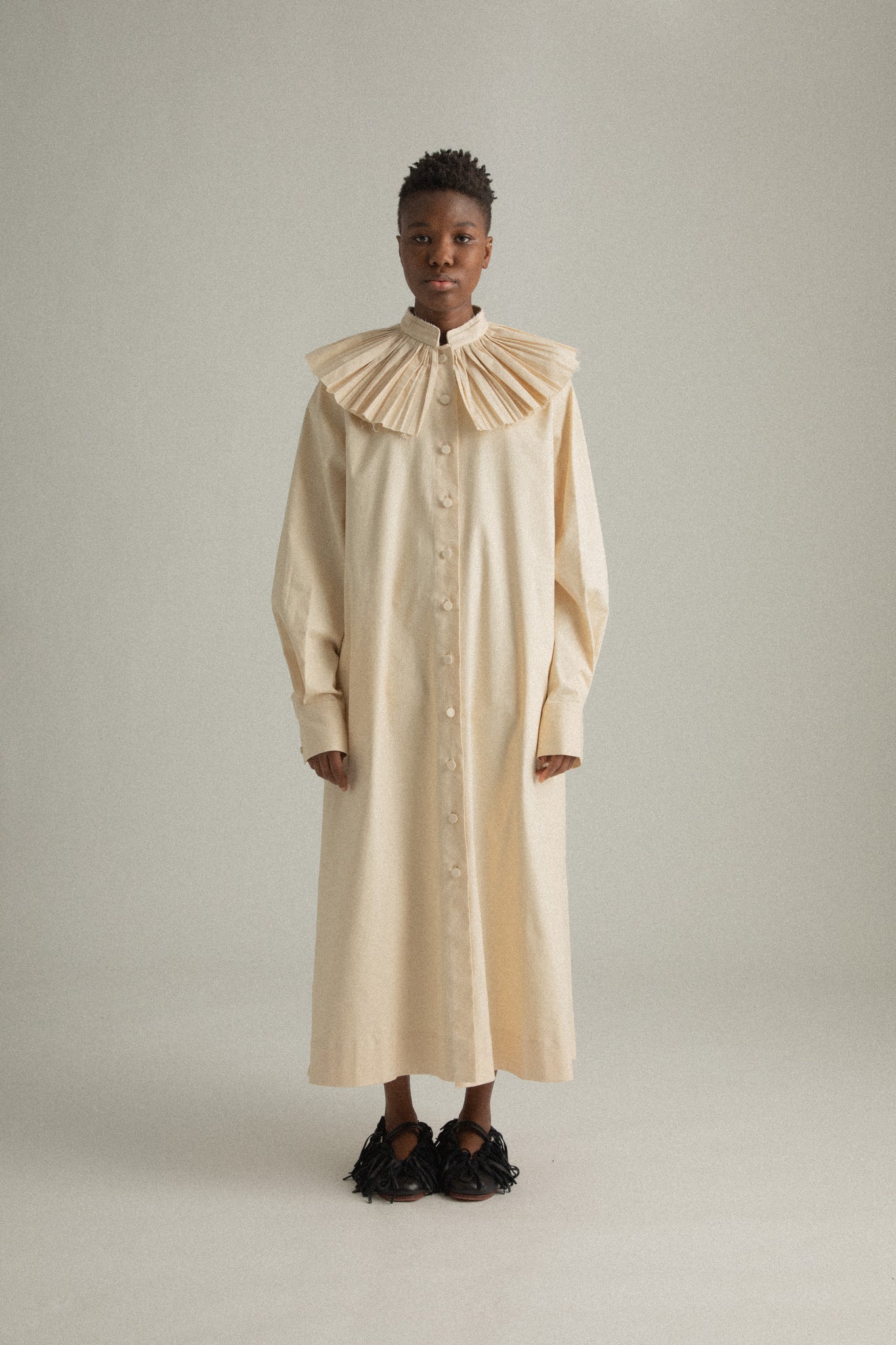 Full front view of Odette Dress in cream compact cotton, showcasing pleated collar and button-front design.