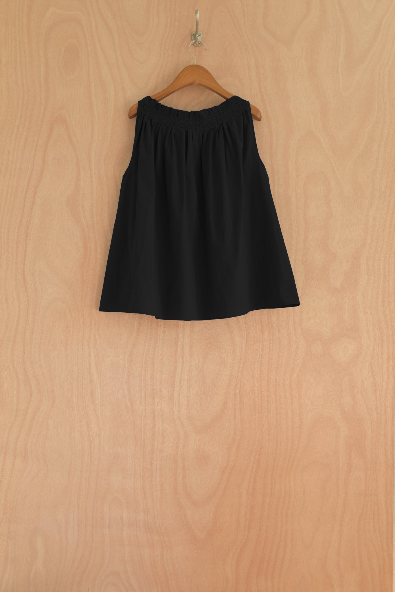 Back view of the Olga Top in black, highlighting the relaxed drape and open silhouette.