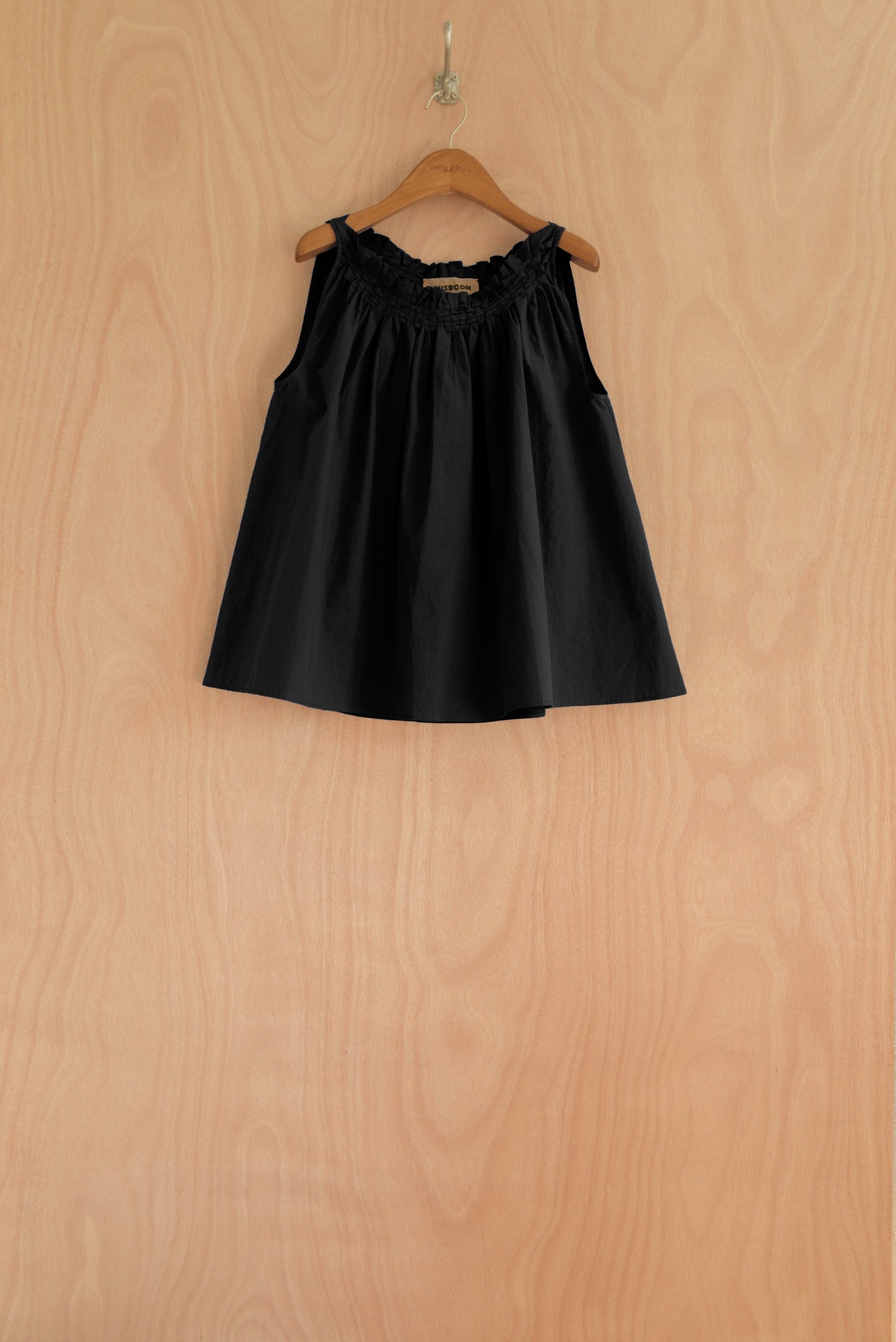 Front view of the Olga Top in black, showcasing the handwoven neckline and airy cut.