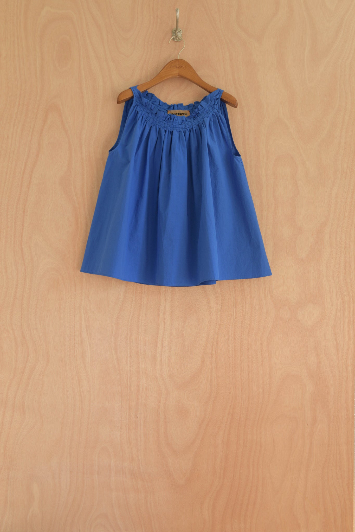 Front view of the Olga Top in blue, showcasing the handwoven neckline and airy cut.