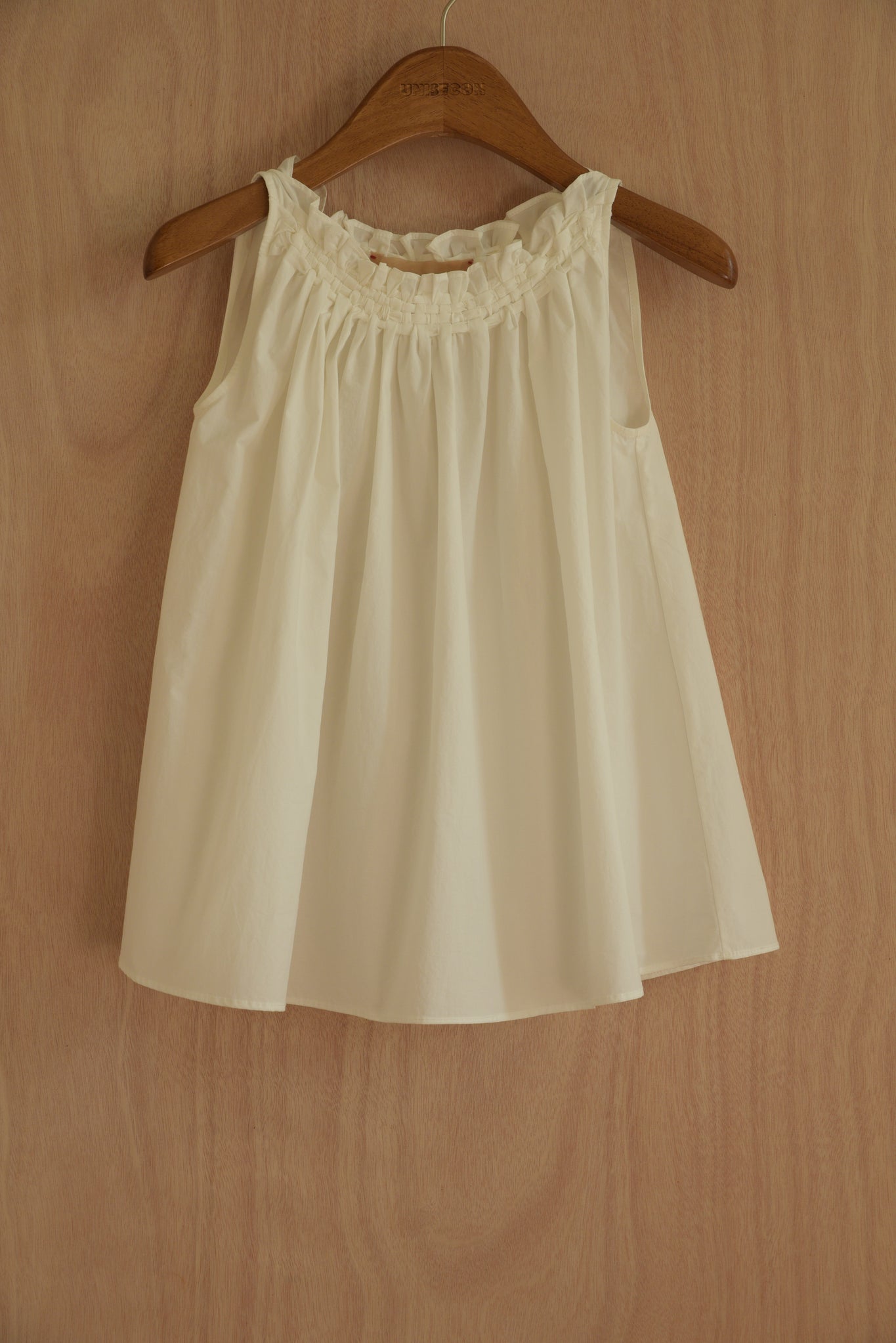  Front view of the Olga Top in white, showcasing the handwoven neckline and flowing silhouette.