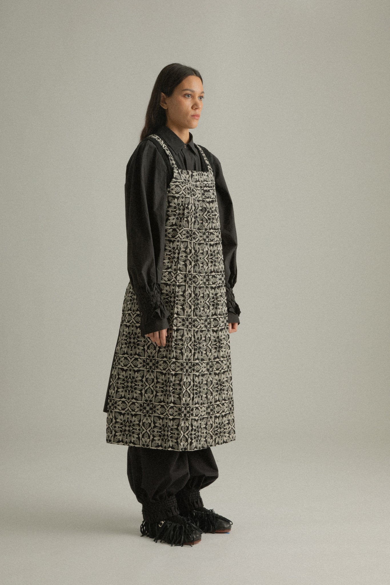 Side view of Rhonda Apron in premium Chinese jacquard cotton, showing the clean silhouette and strap detail.