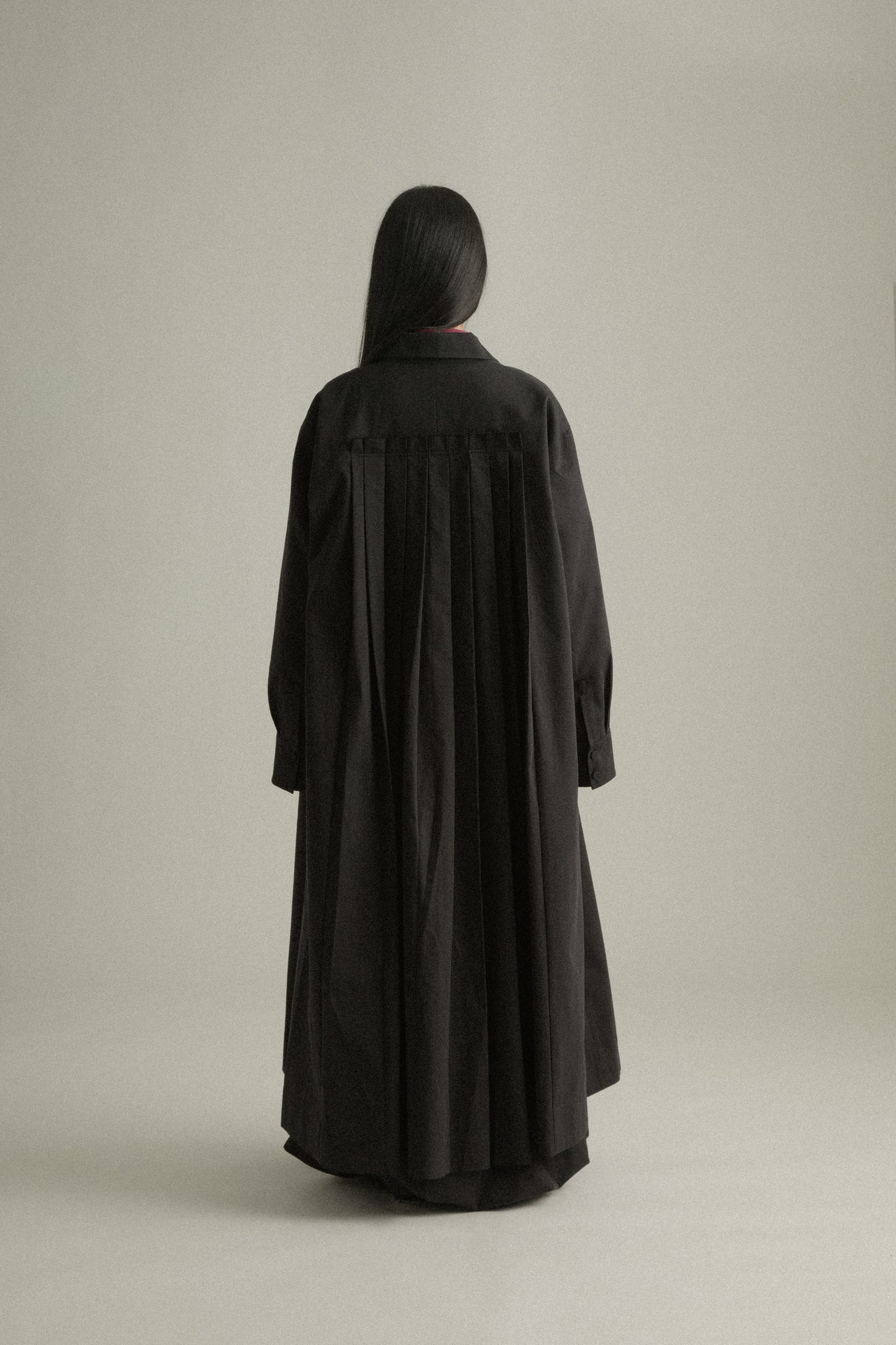 Back view of Romy Coat, featuring the signature pleated detail for movement and ease.