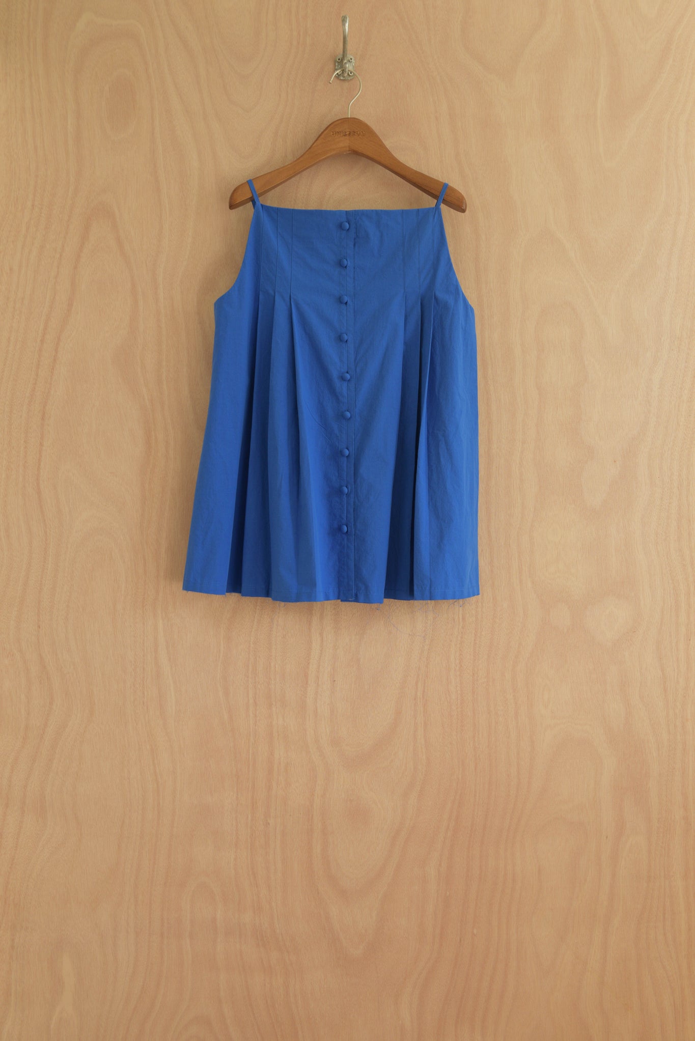 Sharrin Top front view in blue structured cotton with hand-pressed pleats