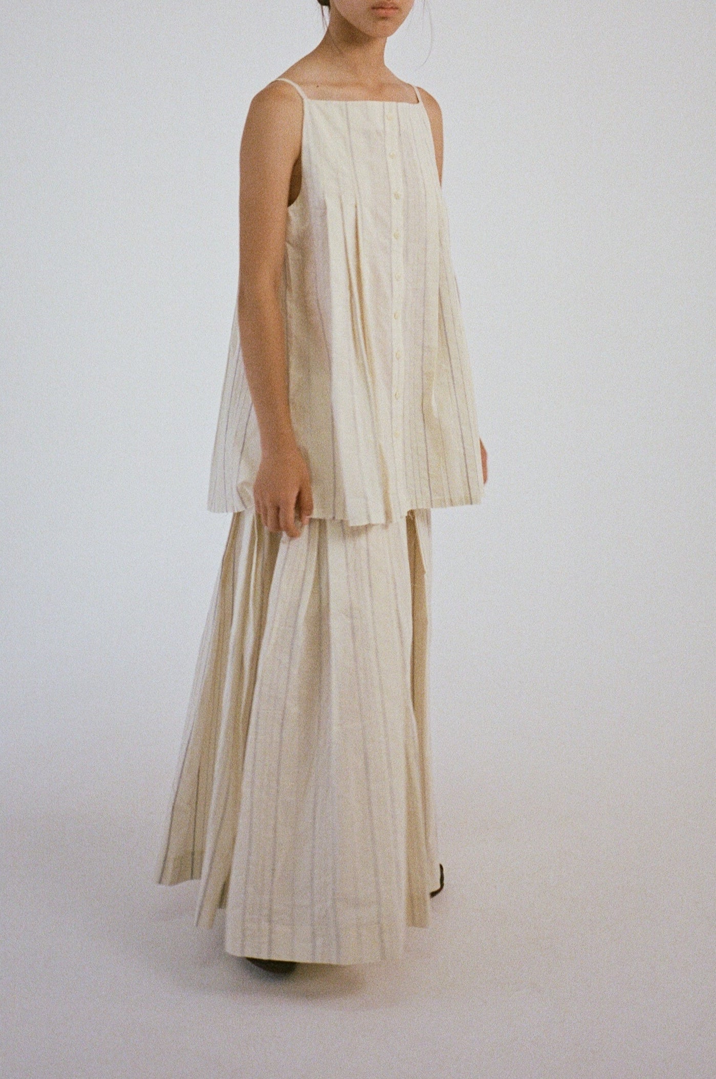 Model wearing the Sharrin Top with matching pleated skirt.