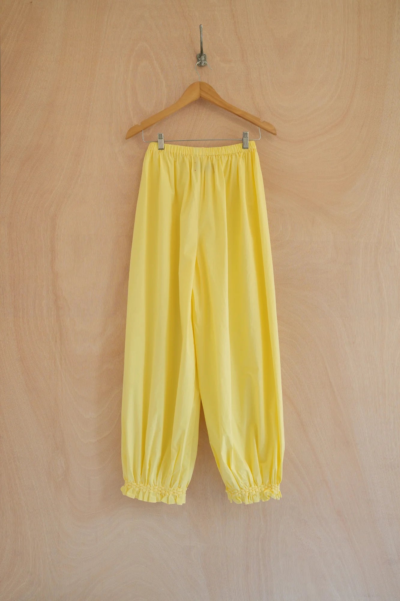 UNISECON Qira pants in yellow, back view