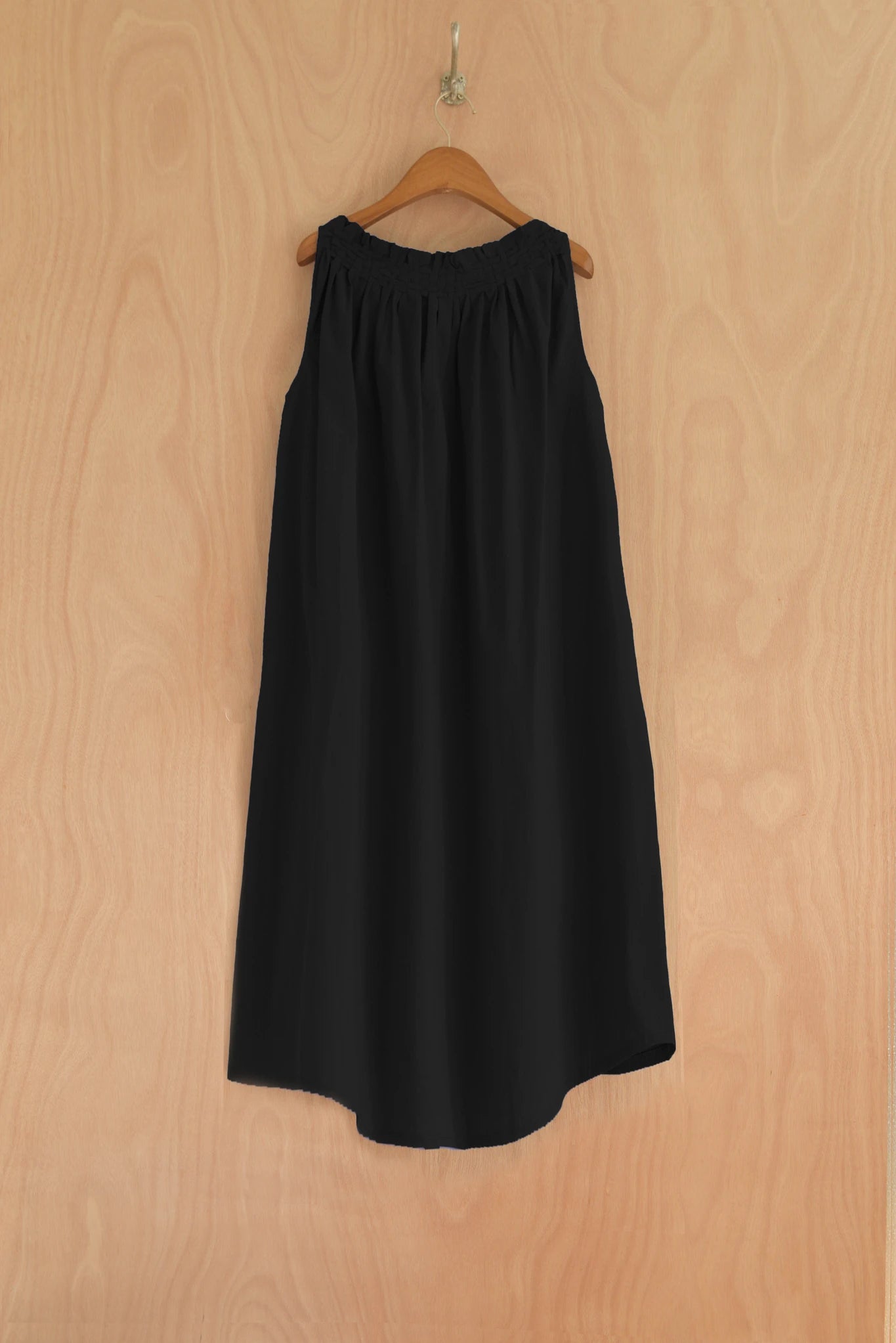 Back view of ankle-length black dress with wide flow